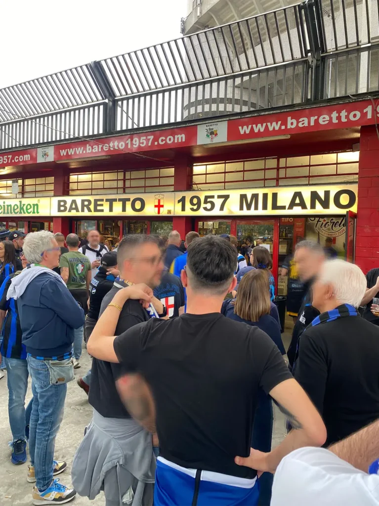 baretto-giuseppe-meazza Aficionados en la previa del Baretto 1957 de San Siro vistiendo ropa casual y bufandas nerazzurre del Inter de Milan.